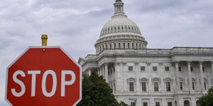 A stop sign is seen in front of the US Capitol dome in Washington, DC, on September 30, 2025. The United States government was barreling towards its first shutdown in six years Tuesday, with funding expiring at midnight barring a breakthrough on deadlocked negotiations between Democrats and Republicans. (Photo by Alex WROBLEWSKI / AFP) (Photo by ALEX WROBLEWSKI/AFP via Getty Images)