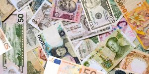 Mosaic collection of currencies from around the world. In the full frame image one can find among others Indian rupee, Chinese yuan, Japanese yen, US dollar, Thai baht, Singapore dollar, Brazilian real, European euro and Mexican peso. The paper money is mixed and the image is full frame.